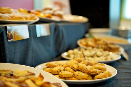 a buffet with plates of food on a table at Mercure Nerocubo Rovereto in Rovereto