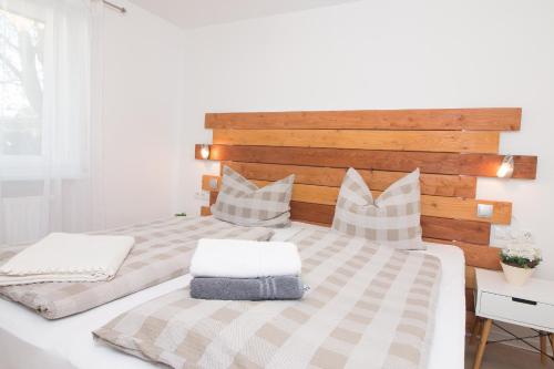 um quarto com uma cama com uma cabeceira e almofadas de madeira em K2 Bungalow - Strandhaus Königsberger Allee 8 - FERIENDOMIZIL HOLLICH em Grömitz
