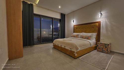 1 dormitorio con cama y ventana grande en SURF PALACE BEACHFRONT APARTMENT Essaouira en Essaouira