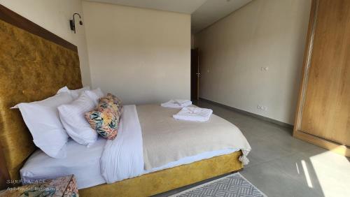 a bedroom with a bed with white sheets and pillows at SURF PALACE BEACHFRONT APARTMENT Essaouira in Essaouira