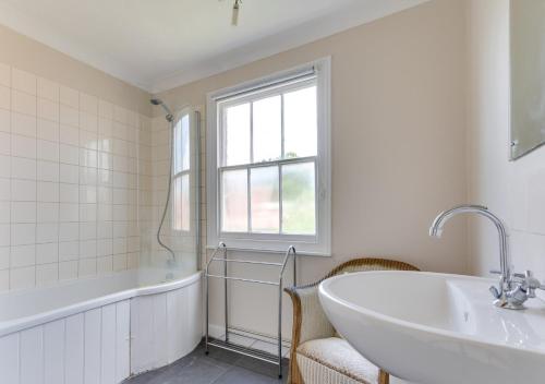 a white bathroom with a tub and a sink at Alma Rise in Melton