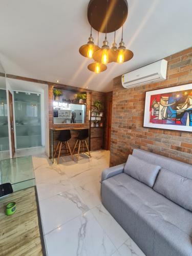 un soggiorno con divano e muro di mattoni di Apartamento em boa viagem a Recife