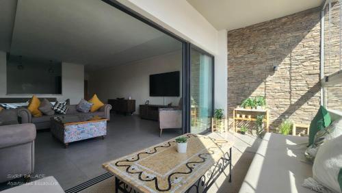 a living room with a couch and a table at SURF PALACE BEACHFRONT APARTMENT Essaouira in Essaouira