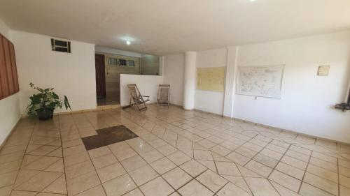 a large room with a tiled floor and white walls at Suíte Centro in São João Batista do Glória