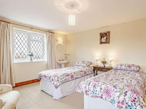 een slaapkamer met 2 bedden, een wastafel en een raam bij 2 Bed in Mattishall 57133 in Mattishall