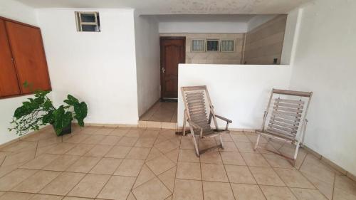 two chairs sitting on a tiled floor in a room at Suíte Centro in São João Batista do Glória