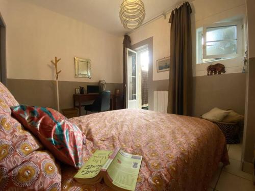une chambre avec un lit avec deux livres dessus dans l'établissement Invitation au voyage, patio privé, à Sète
