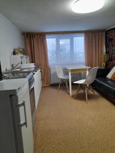 een keuken en een woonkamer met een tafel en stoelen bij Автентичний Лофт Апартамент в Карпатах in Krivorovnya