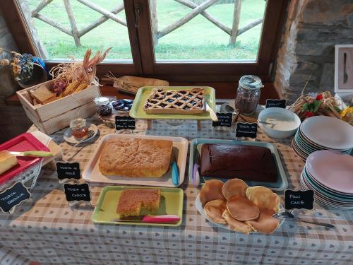 una mesa cubierta con bandejas de pan y otros alimentos en Agriturismo Ca' de' Magnani, en Baragazza