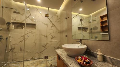 a bathroom with a sink and a glass shower at SURF PALACE BEACHFRONT APARTMENT Essaouira in Essaouira
