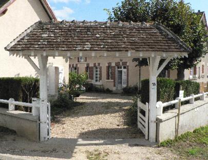 een wit huis met een prieel ervoor bij La Petite Tuilerie in Villefranche-Sur-Cher