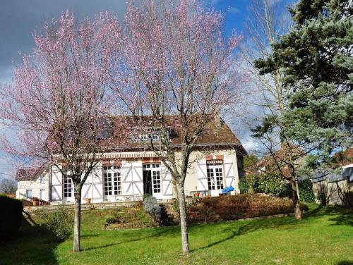 una casa blanca con dos árboles delante de ella en La Petite Tuilerie en Villefranche-Sur-Cher