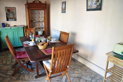 - une table à manger avec des chaises, une table en bois et des chaises dans l'établissement La Petite Tuilerie, à Villefranche-Sur-Cher