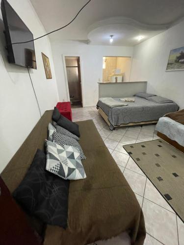 a bedroom with two beds and a flat screen tv at Apto Antonio Centro in Campos dos Goytacazes