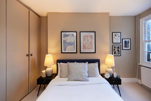 The Elmington Estate Place - Elegant 1BDR Flat في لندن: غرفة نوم بسرير كبير فيها مصباحين