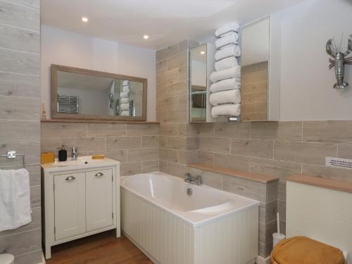 a bathroom with a sink and a mirror at Waterland Farmhouse in Holsworthy