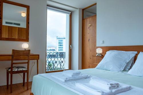 1 dormitorio con 1 cama, escritorio y ventana en The View Point, en Ponta Delgada