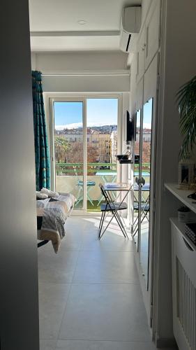 un salon avec une grande fenêtre et un canapé dans l'établissement Studio NICE CENTRE sur Avenue Jean Medecin MER à 8 minutes de marche, à Nice