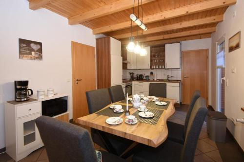 a kitchen and dining room with a wooden table and chairs at Ferienhaus Auszeit in Westoverledingen