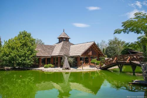 a large house with a pond in front of it at Etno selo Stanišići Hotel Pirg in Dvorovi