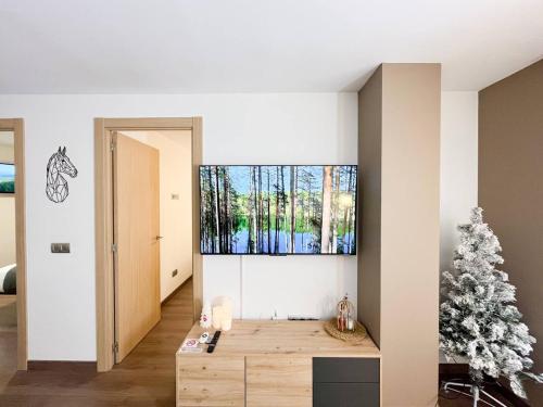 a living room with a christmas tree and a large window at En Pleno Centro Moderno&Práctico, 1 Plaza Parking - Andorra la Vella l by BonesVacances in Andorra la Vella