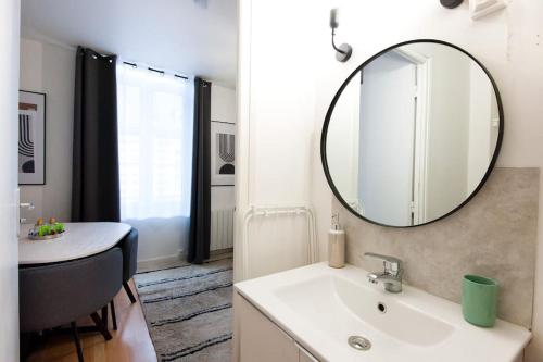 une salle de bain avec un lavabo et un miroir dans l'établissement La Casa : Logement en centre ville, Cathédrale, à Amiens