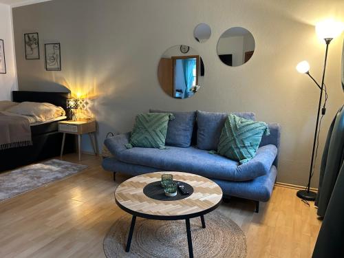 a living room with a blue couch and a table at Wohntraum im Herzen von Pregarten in Pregarten
