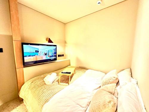 - une chambre avec un lit et une télévision à écran plat dans l'établissement Burj Khalifa View Brand New Luxury Living, à Dubaï