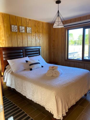 a bedroom with a bed with two towels on it at Refugio del bosque in Futrono