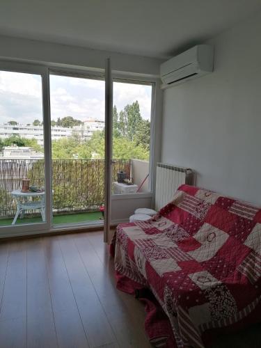 une chambre avec un lit et un balcon dans l'établissement Appartement Circé - Montpellier Nord-Hopitaux-Facultés, à Montpellier