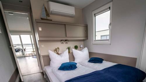 Hausboot Neptun - LP3 في Laasow: غرفة نوم عليها سرير ووسادتين زرقاوين
