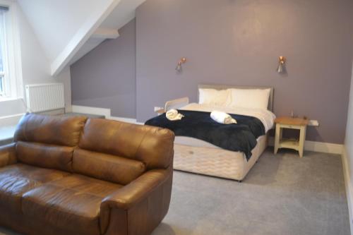 sypialnia z łóżkiem i skórzaną kanapą w obiekcie Ashbrooke Homestay w mieście Sunderland