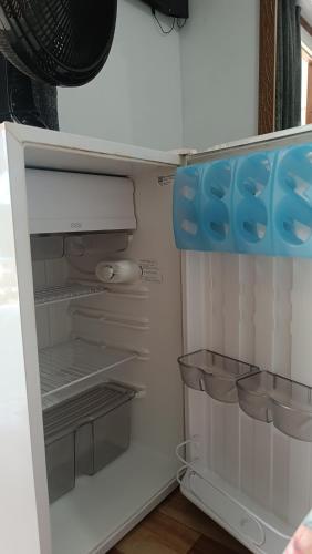 an empty refrigerator with its door open in a room at Pousada Sobre as Ondas - ILHA DO MEL - PR in Ilha do Mel