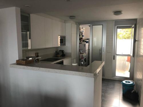 a kitchen with white cabinets and a counter top at Ático en Parque Natural Cabo de Gata in Carboneras