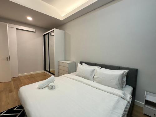 a bedroom with a large white bed with white pillows at Sentral Luxury Suites KL in Kuala Lumpur