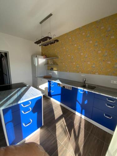 cocina con armarios azules y encimera en Entzückendes Häuschen, neu ren., en Groß-Siegharts