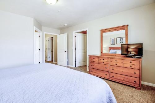 a bedroom with a bed and a dresser with a television at Red Cliff 3J in Moab