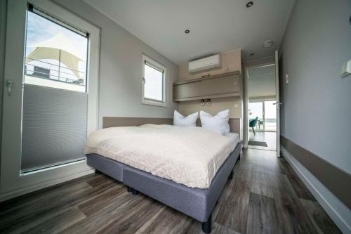 a bedroom with a large bed and a large window at Hausboot Albatros - LP4 in Laasow