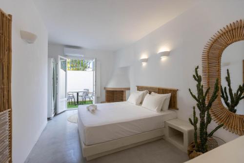 a white bedroom with a white bed and a cactus at ACOYA SUMMER HOME in Kampos Paros