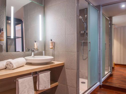 La salle de bains est pourvue d'un lavabo et d'une douche. dans l'établissement Mercure Dieppe La Présidence, à Dieppe