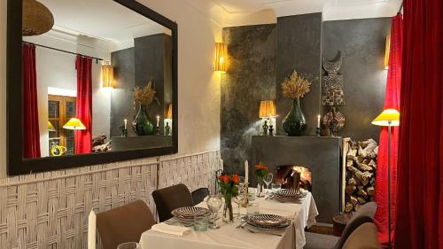 a dining room with a table and a fireplace at Riad Dar Zaman in Marrakech