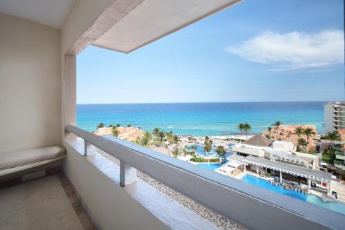 a balcony with a view of the beach and the ocean at Wyndham Grand Cancun All Inclusive Resort & Villas in Cancún
