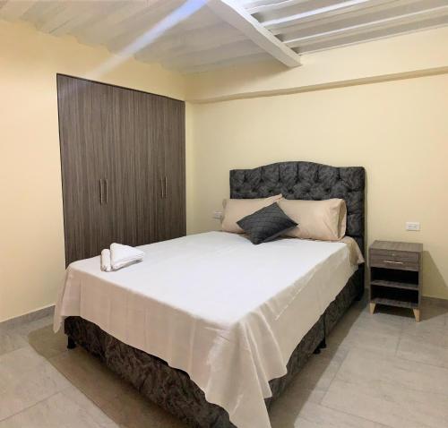 1 dormitorio con 1 cama grande con sábanas blancas en Posada RoRi en Choachí