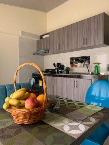 a basket of fruit on a table in a kitchen at Posada RoRi in Choachí