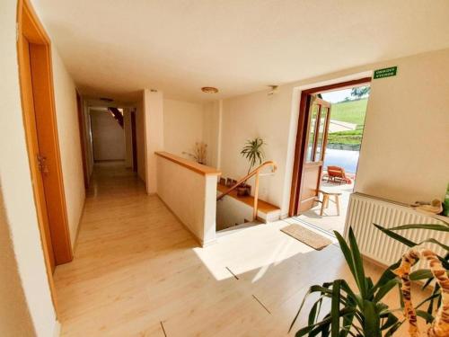 a room with a hallway with a view of a balcony at Ferienhaus am Waldrand mit Schwimmbad und Sauna in Strážné