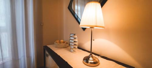 a lamp sitting on a table next to a window at La casa di Bianca - Casa Vacanze in Villa Opicina