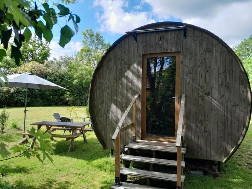a circular cabin with a table and an umbrella at " village tonneaux de tirpoil " in Montilliers