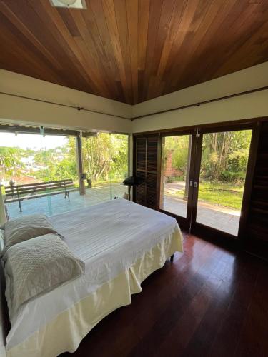 um quarto com uma cama e uma grande janela em Mansao gloria em Joinville