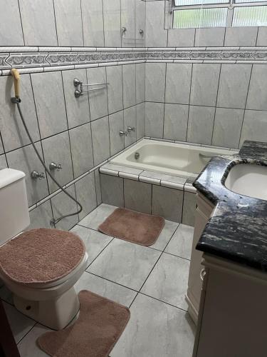 uma casa de banho com um WC, um lavatório e uma banheira em Mansao gloria em Joinville