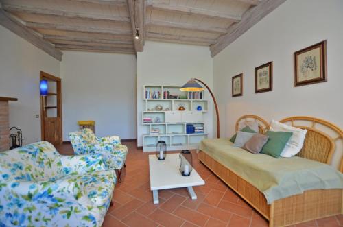 sala de estar con cama y silla en Villa Piandisette, en Cetona